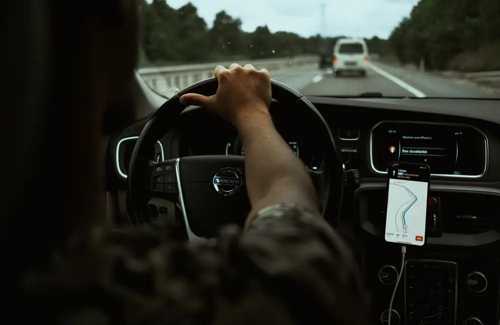 Motorista utilizando navegação no celular durante seu deslocamento